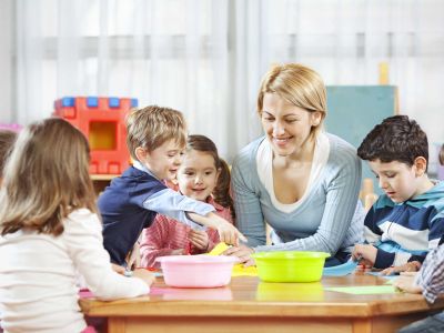 Erzieherin einer Kita arbeitet mit Kindern