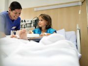Sozialassistentin im Krankenhaus bei Arbeit mit Kind